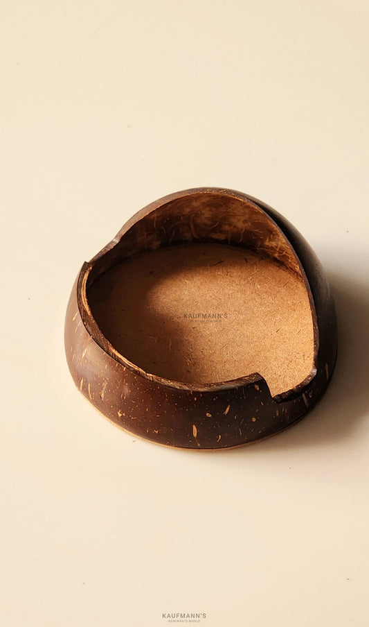 A coconut shell phone holder with a smooth, polished finish, displaying an oval shape with a visible crack on the side.