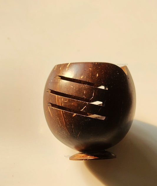 A beige pen holder made from coconut shell with a smooth finish and a slit in the side, placed on a neutral background.