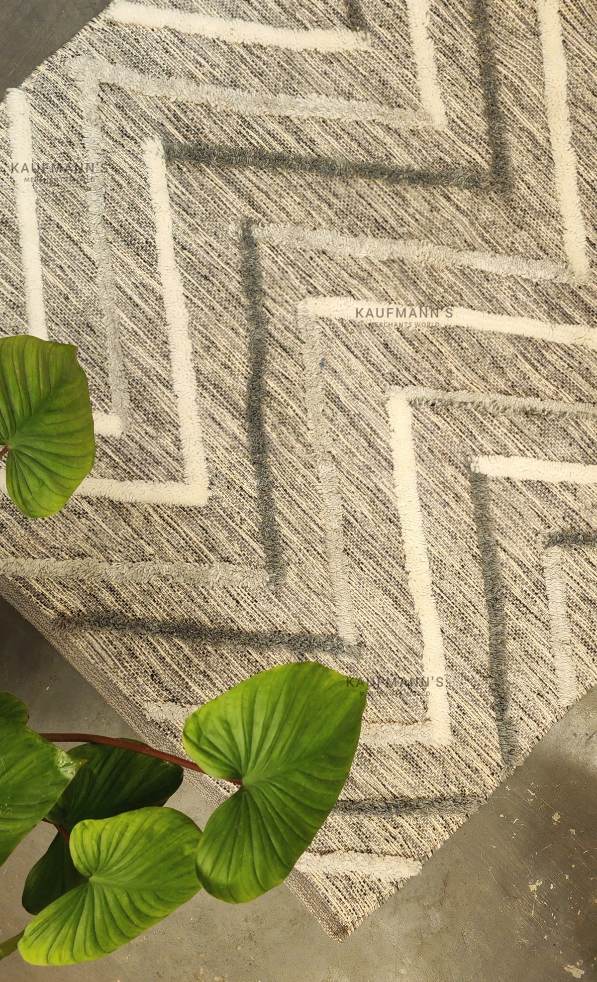 A multicoloured geometric-patterned cotton rug with a jute leaf on top, showcasing a textured design.