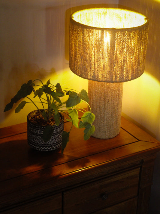 Jute Table Lampshades with textured shade and plant on a wooden surface