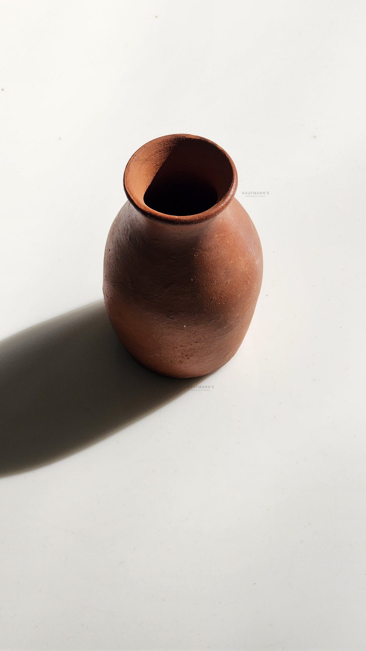 A handcrafted terracotta pot on a white background.